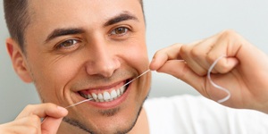 A guy flossing his teeth