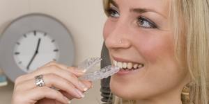 Woman holding Invisalign tray