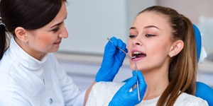 A dentist checking a patient’s mouth